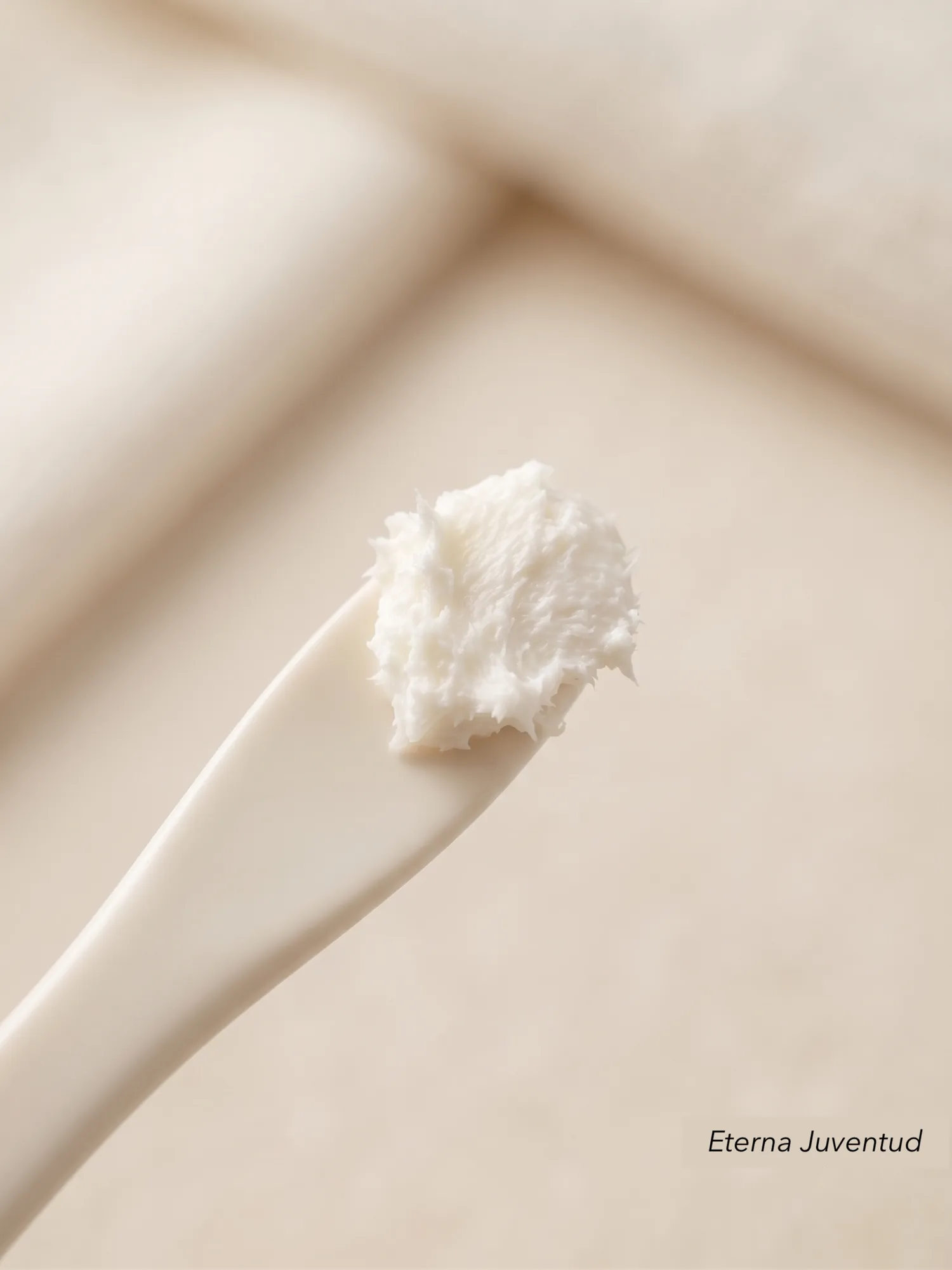 Detalle de crema Eterna Juventud sobre una espátula en luz cálida